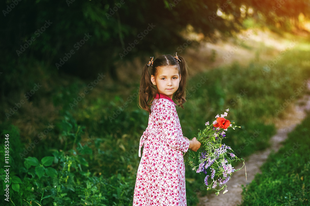 Beautiful little girl with wildflowers in the Park Beautiful little girl with wildflowers in the Park