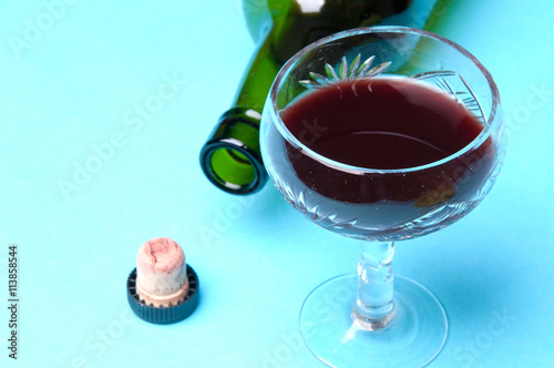 glass and bottle of wine isolated on a blue background