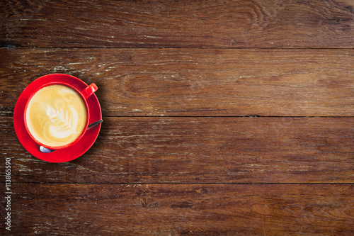 red coffee cup on old wood background with space.