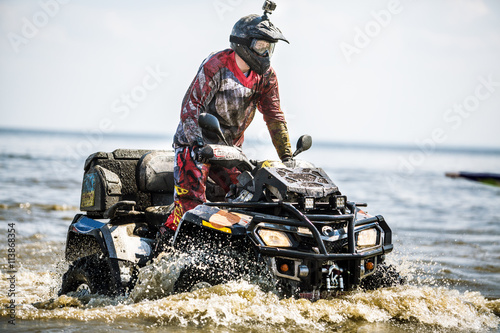 Travel on ATVs in river.ATV in action, having fun with sport.The photo