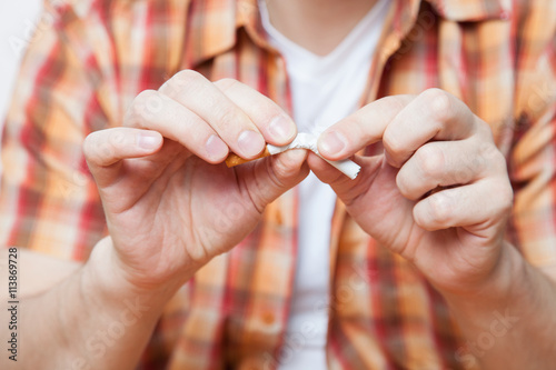 Obraz na plátně Man holding a broken cigarette