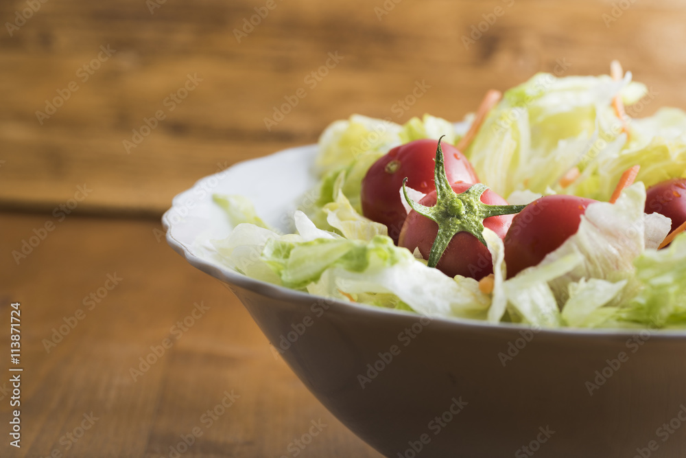 fresh lettuce salad with carrots cut into strips and whole tomatoes.