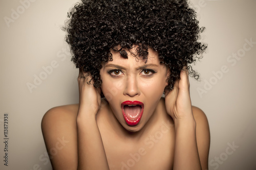 nervous young woman with black curly wig shouting on you