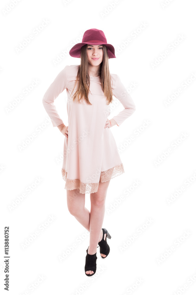 Relaxed pretty female wearing hat and posing in casual dress