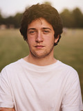 portrait of a teenage man in a park