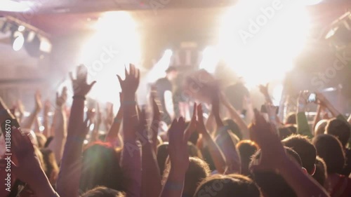 the end of the concert, Large group of happy people enjoying rock concert, clapping with raised up hands, lights from the stage 2