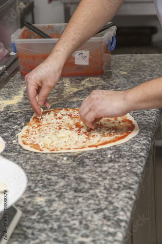 Man chef with raw pizza.