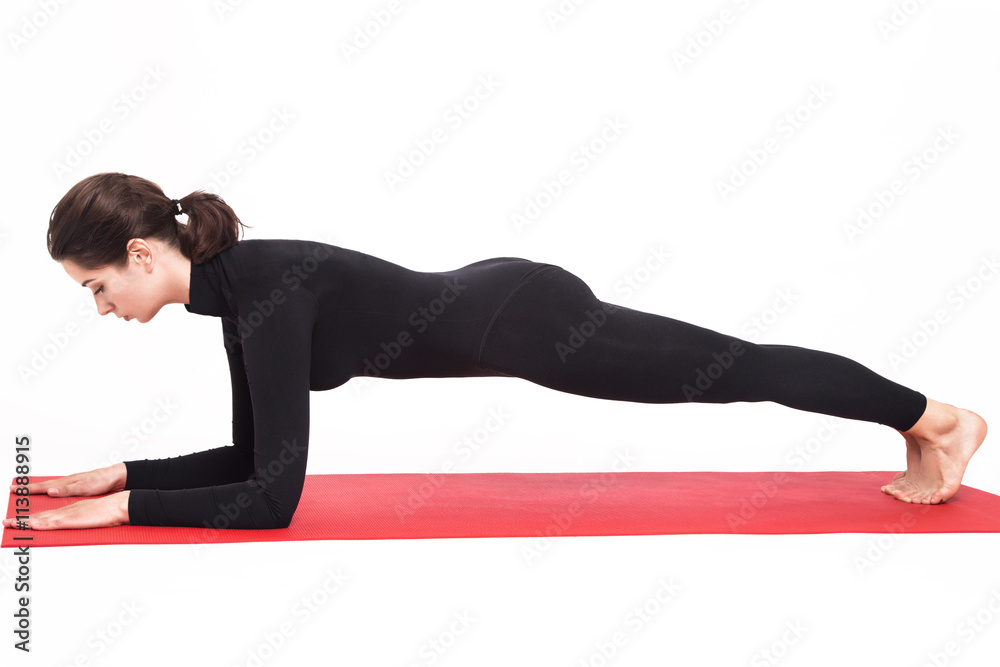 Beautiful athletic girl in a black suit doing yoga. Supta Virasana asana lightning sleeping pose. Isolated on white background. Beautiful athletic girl in a black suit doing yoga. Supta Virasana asana lightning sleeping pose. Isolated on white background.
