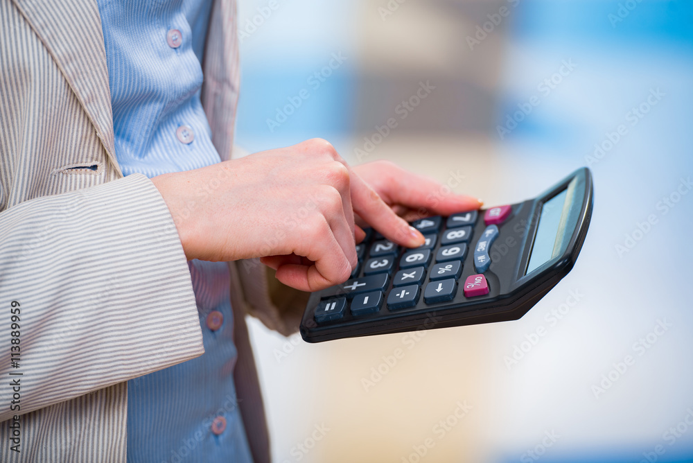 Hands calculating profit on the calculator Hands calculating profit on the calculator