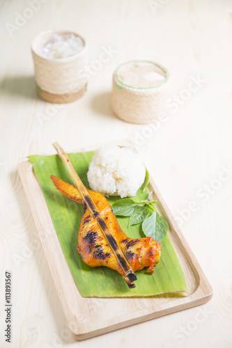 grilled chicken wings with steamed glutinous rice on banana leaf