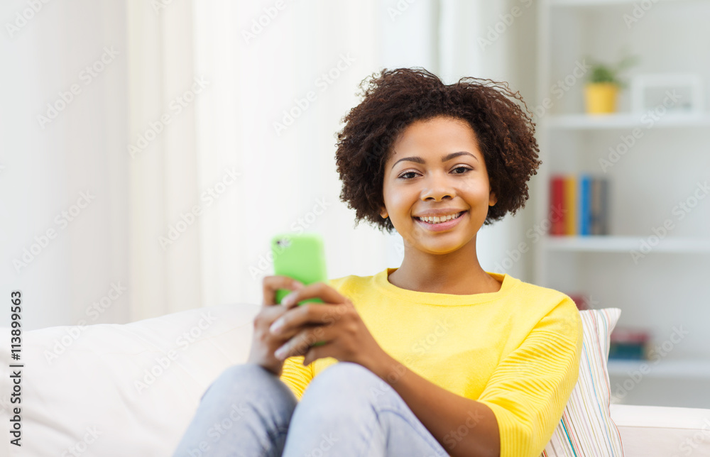 happy african woman with smartphone at home