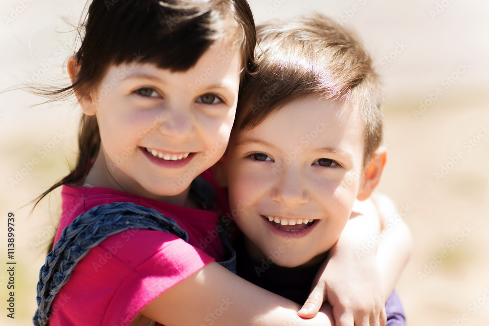 two happy kids hugging outdoors two happy kids hugging outdoors