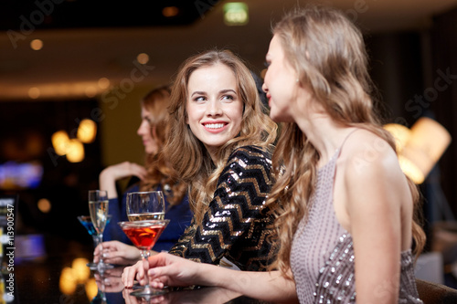 happy women with drinks at night club