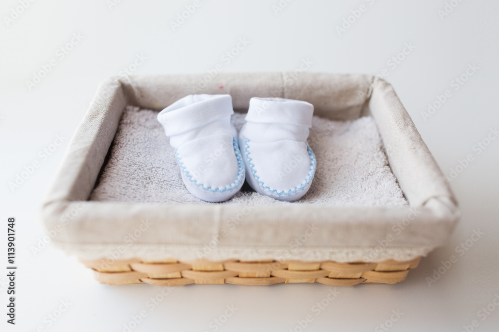 close up of baby bootees for newborn boy in basket close up of baby bootees for newborn boy in basket