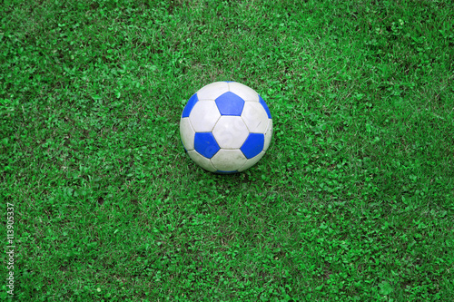 Blue white colored soccer ball on green grass.