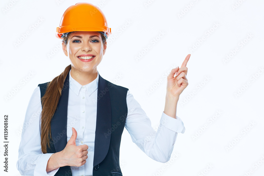 Woman builder in helmet points finger at copy space on white ba Woman builder in helmet points finger at copy space on white ba