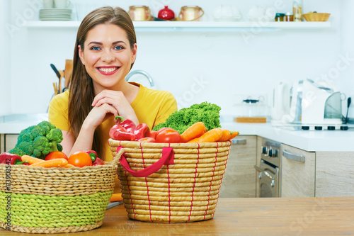 Portrait of young woman in kitchen with wegetables. Healthy foo photo