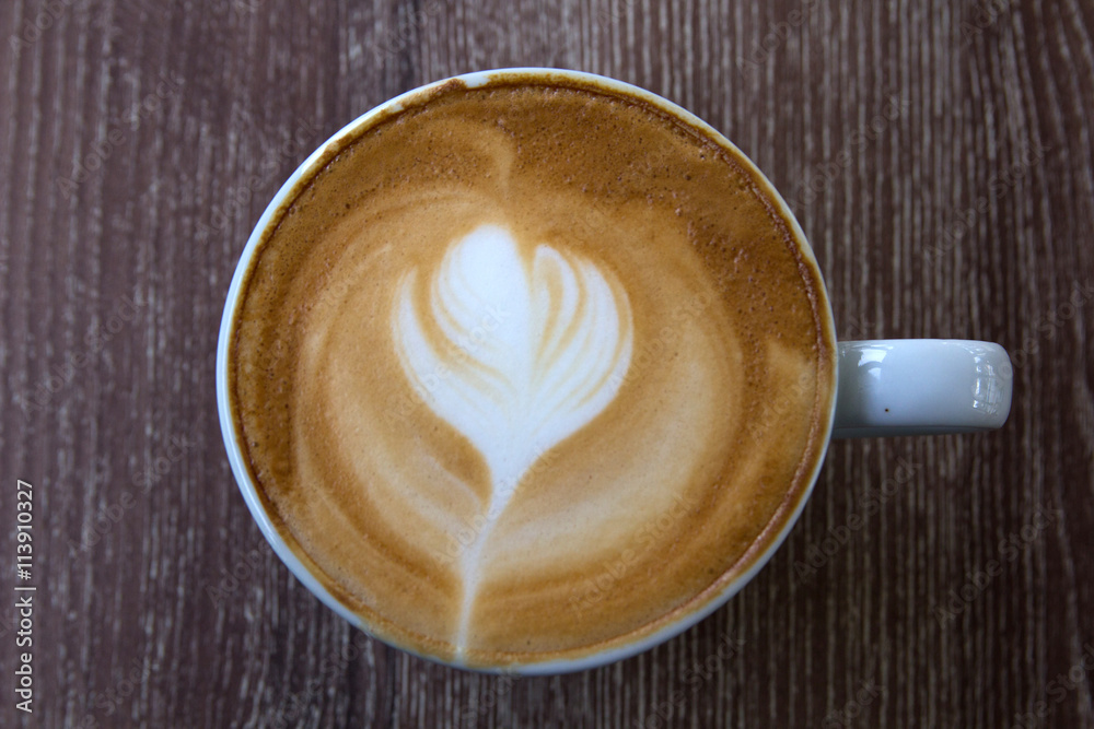 Cup of latte art coffee with froth shape heart and wooden backgr Cup of latte art coffee with froth shape heart and wooden backgr