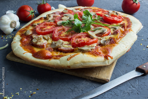 homemade pizza with sausage and tomatoes.
