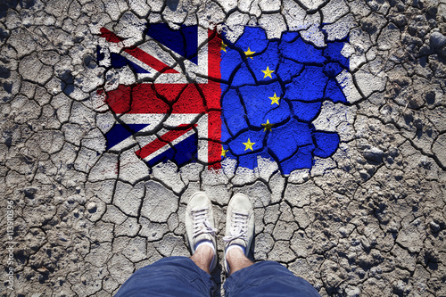 Point of view of a man standing on cracked soil with United Kingdom and European union flags. photo