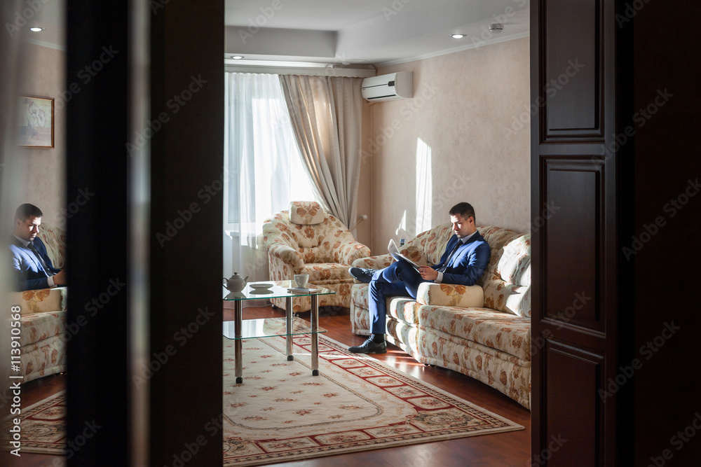 Young businessman reading newspapers and drinking coffee Young businessman reading newspapers and drinking coffee