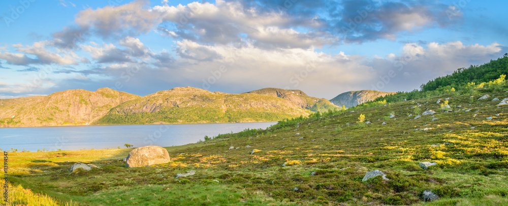 Panorama of a rocky hill at sunset in a Norwegian mountain, with a lake in the background Panorama of a rocky hill at sunset in a Norwegian mountain, with a lake in the background