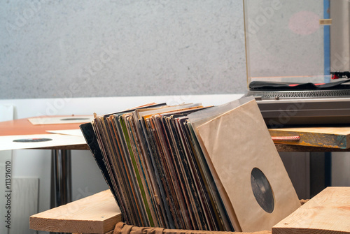Retro styled image of a collection of old vinyl record lp's with sleeves on a wooden background