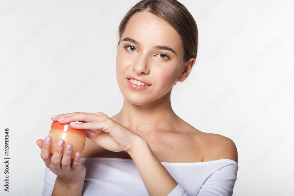 Girl is holding jar with moisturizing cream
