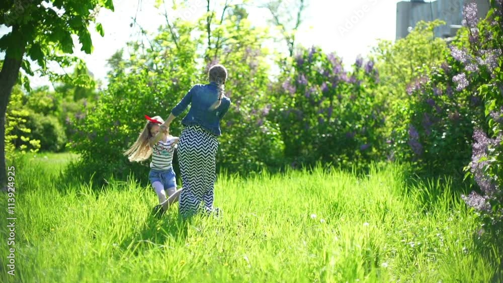 young mother with her daughter playing in a spring park young mother with her daughter playing in a spring park