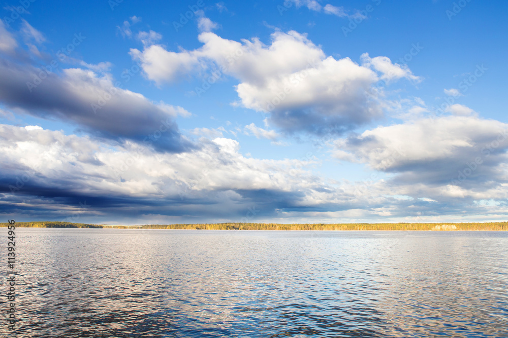 Fototapeta premium Blue Skies and Clouds Over Evening Lake in Finland