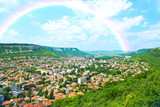 City view with mountains, nature landscape and rainbow