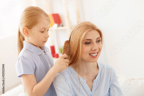 Daughter combing hair of mother