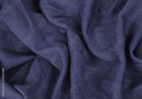Fabric textures - a close up of navy blue scarf material folds to form a page background
