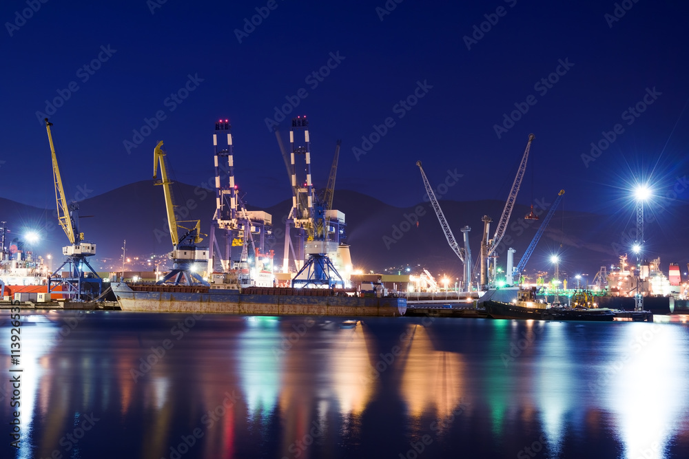 Illuminated cargo port, ships and cranes.