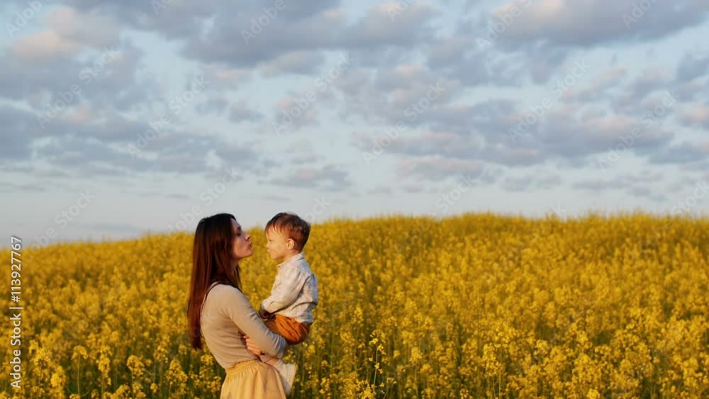 mother holding her son at field at sunset. Slow mo mother holding her son at field at sunset. Slow mo