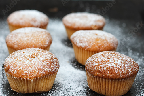 muffins in powdered sugar on a dark