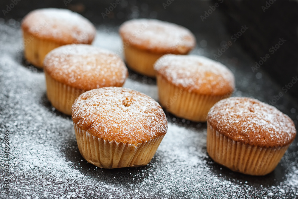 muffins in powdered sugar on a dark