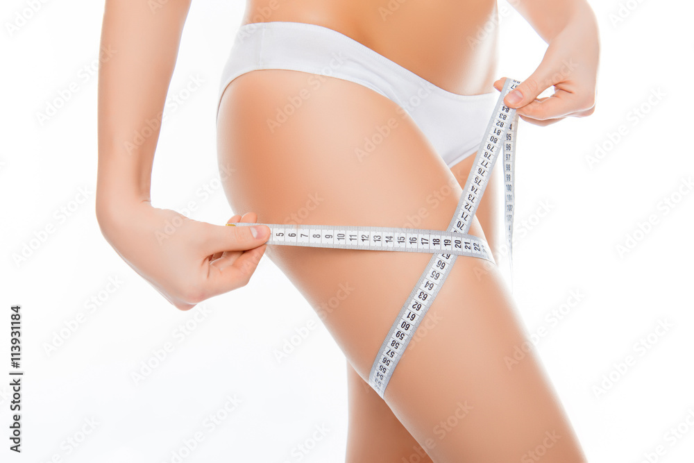 Close up photo of woman measuring her leg's size with tape measu