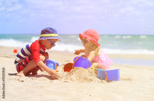 kids play with sand on summer beach