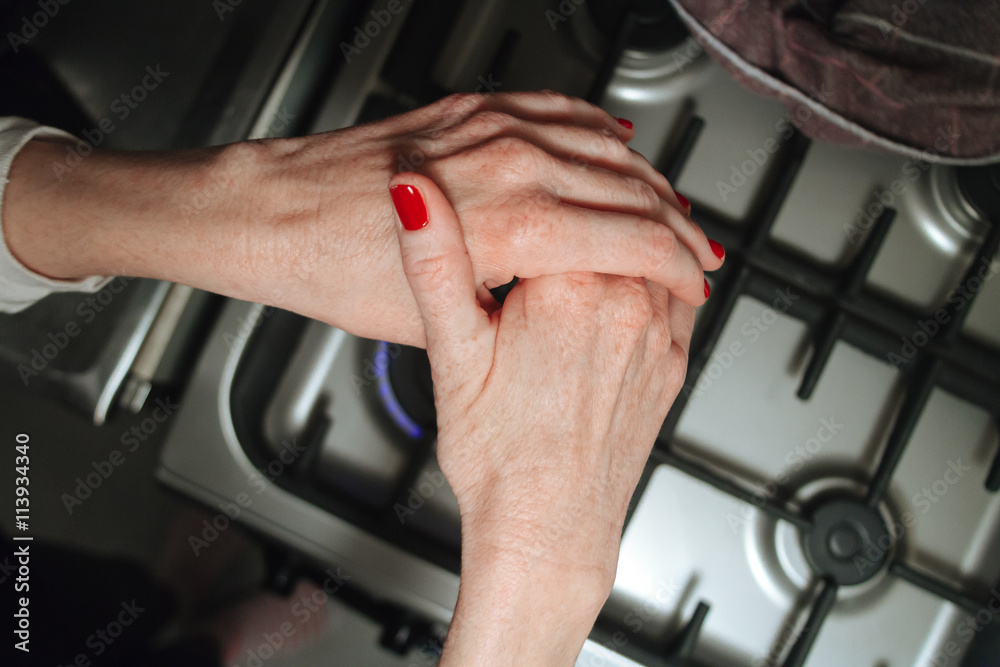 Woman hands on a burner heated