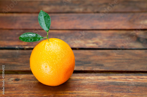 Single orange fruit on wooden table