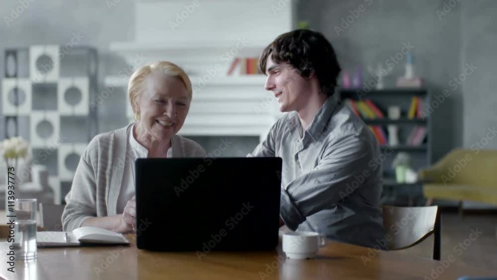 Grandson Teaching Grandmother How to Use a laptop PC. they smile and laugh Grandson Teaching Grandmother How to Use a laptop PC. they smile and laugh