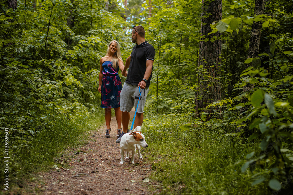 Fototapeta premium Attractive couple on a walk with a dog.