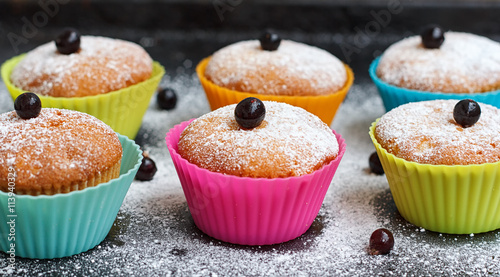 Muffins with black currant in silicone forms sprinkled