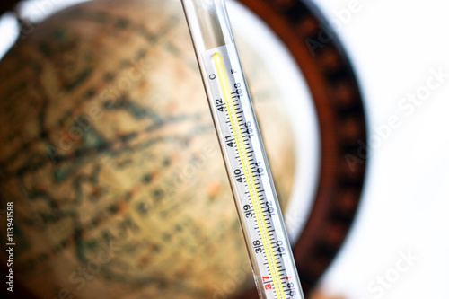 thermometer with antique globe background
