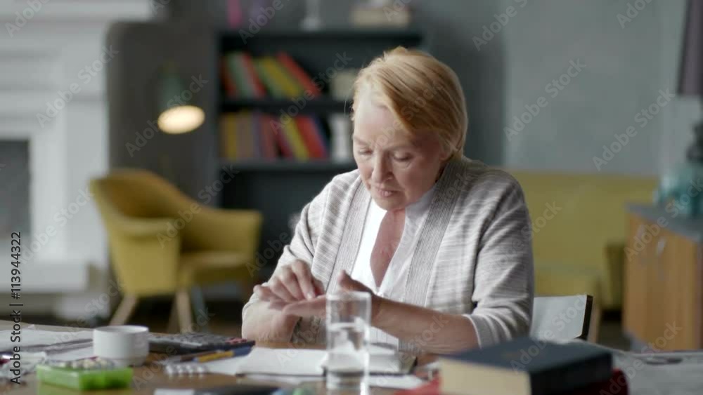 Unhappy troubled elderly woman incredulously looks at a pill. don't want to take medical drugs Unhappy troubled elderly woman incredulously looks at a pill. don't want to take medical drugs