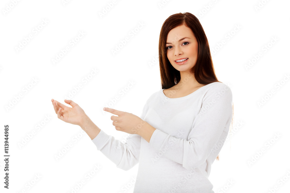 Smiling young woman shows something Smiling young woman shows something