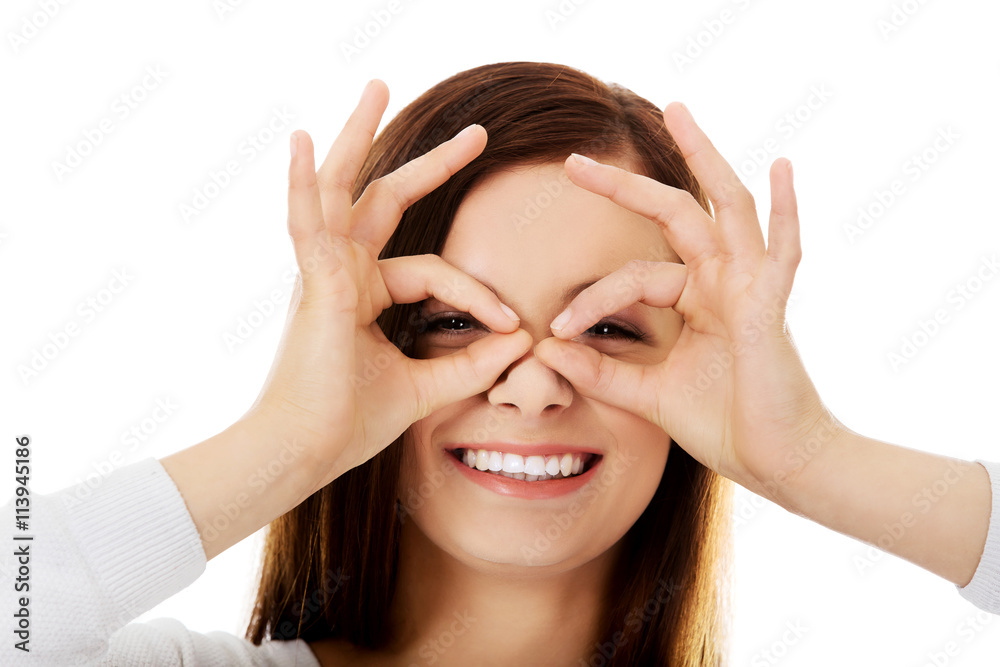 Happy woman making a pair of glasses with her hands Happy woman making a pair of glasses with her hands