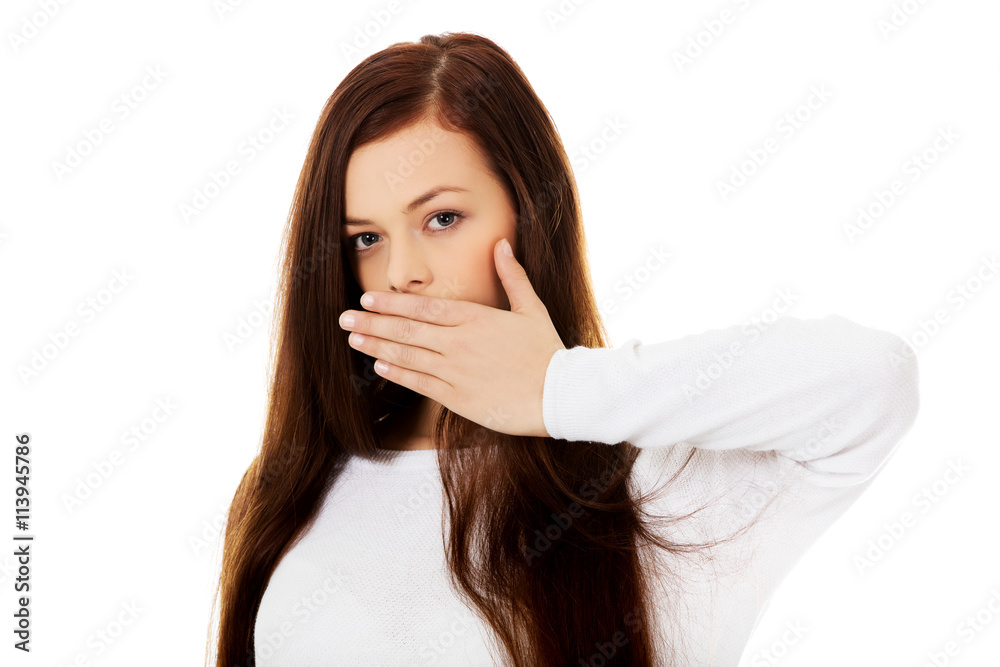 Young woman covering mouth because of shame Young woman covering mouth because of shame