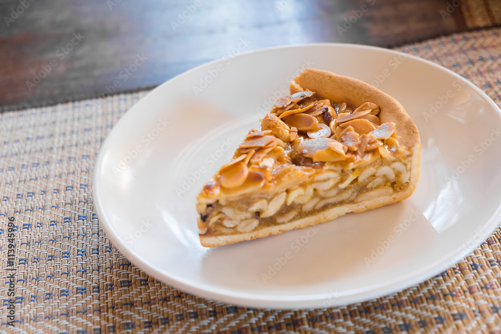 A slice of Almonds pie, on a plate and ready to eat A slice of Almonds pie, on a plate and ready to eat